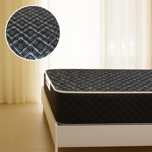Black quilted mattress on bed frame with fabric texture close-up in a bright bedroom
