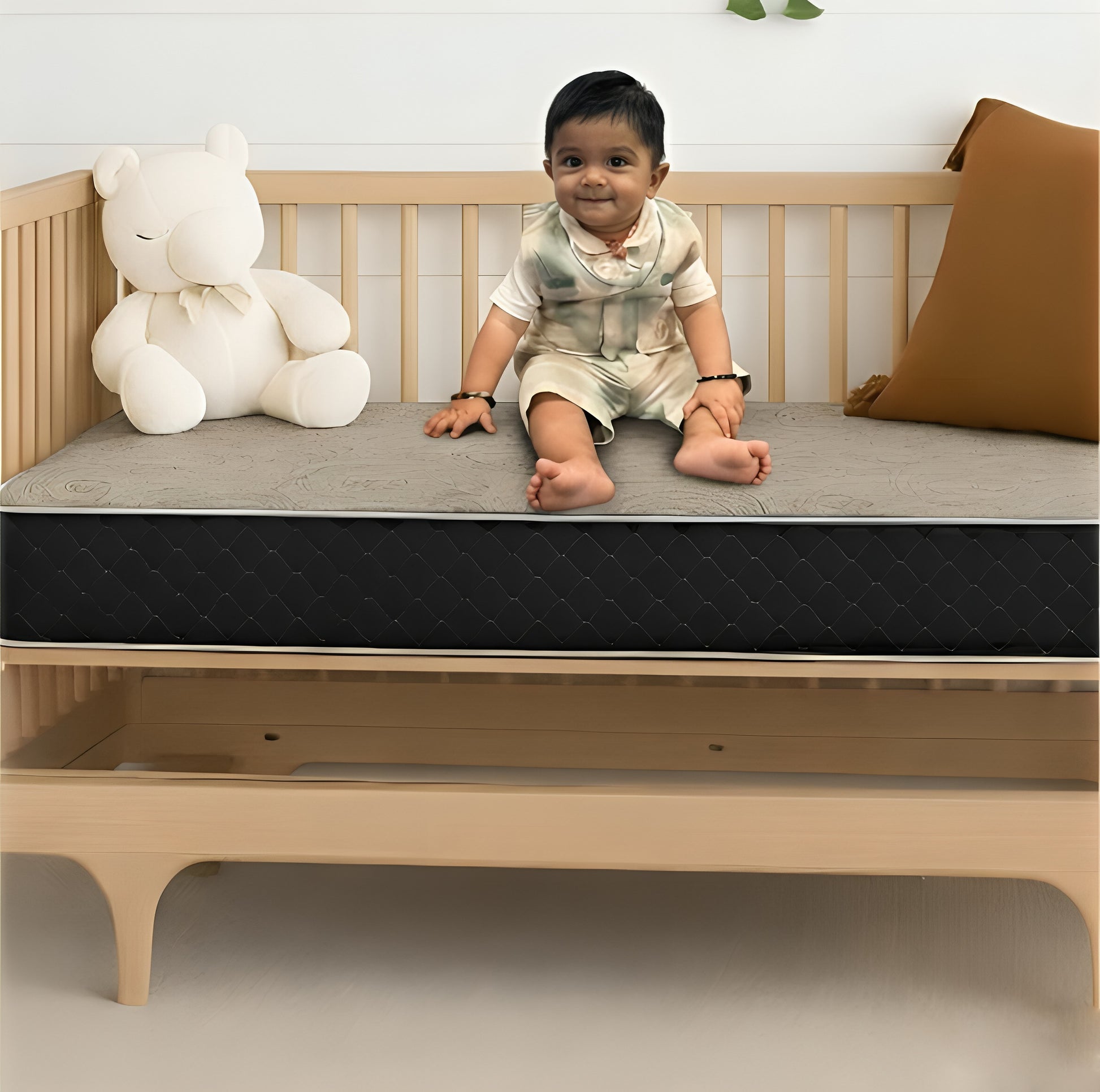 Toddler sitting on a crib mattress in a wooden cot – SleepWell baby and kids mattress