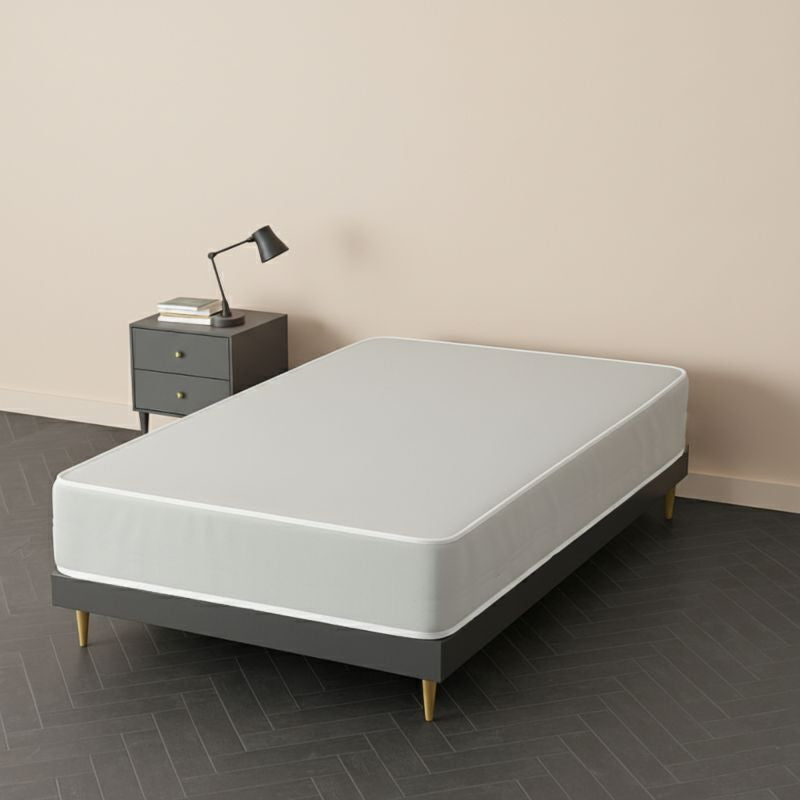 White mattress on a grey bed frame with wooden legs, in a blush pink bedroom setting – SleepWell